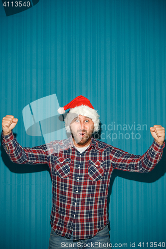 Image of Smiling christmas man wearing a santa hat