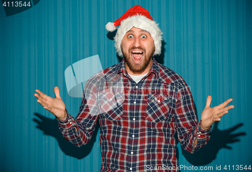 Image of Smiling christmas man wearing a santa hat