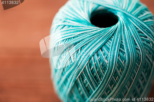 Image of close up of turquoise knitting yarn ball on wood