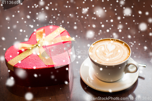 Image of close up of gift box and coffee cup on table