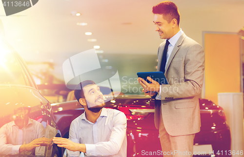 Image of happy man with car dealer in auto show or salon