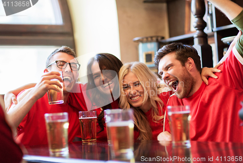 Image of football fans or friends with beer at sport bar