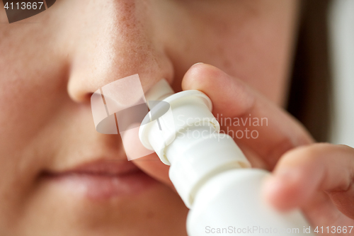 Image of close up of sick woman using nasal spray