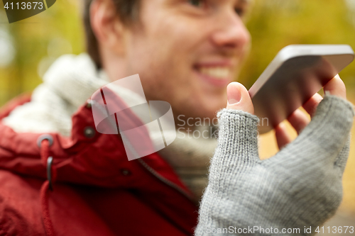 Image of close up of man recording voice on smartphone