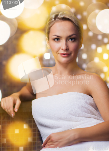 Image of beautiful young woman sitting in bath towel