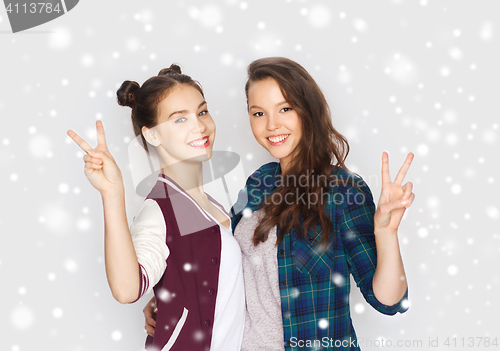 Image of happy teenage girls hugging and showing peace sign