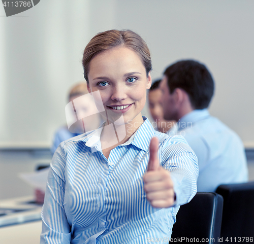 Image of group of smiling businesspeople meeting in office