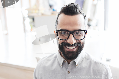 Image of smiling man with eyeglasses and beard at office