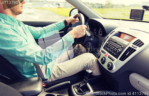 Image of close up of young man driving car