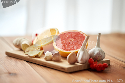 Image of citrus, ginger, garlic and rowanberry on wood