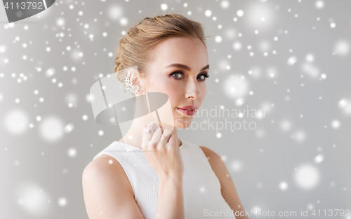 Image of woman in white dress with diamond jewelry and snow