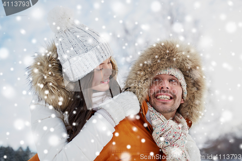 Image of happy couple having fun over winter background