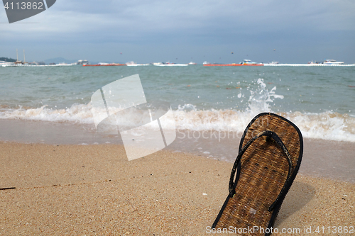 Image of Beach slippers on a sandy beach