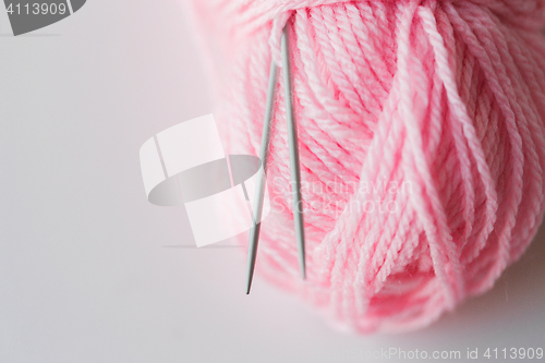 Image of close up of knitting needles and pink yarn ball 