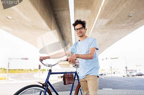 Image of hipster man with fixed gear bike under bridge