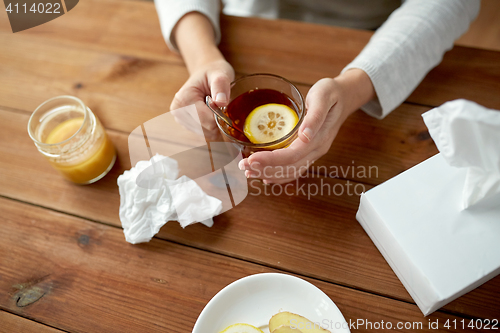 Image of close up of ill woman drinking tea with lemon