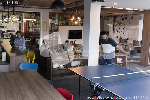 Image of playing ping pong tennis at creative office space