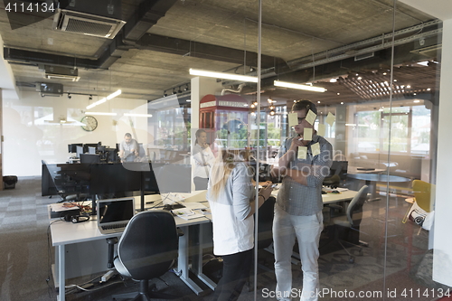 Image of young couple at modern office interior writing notes on stickers