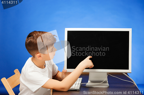 Image of School-age boy sitting with the monitor laptop at studio