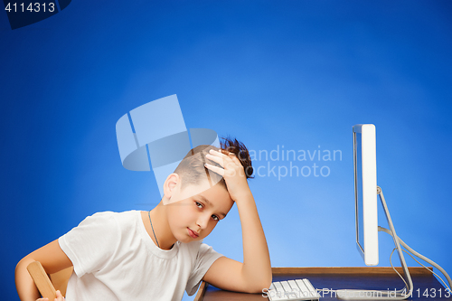 Image of School-age boy sitting in front of the monitor laptop at studio
