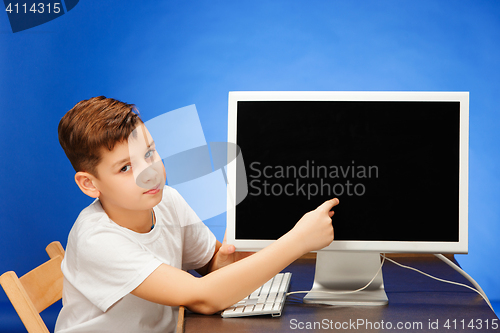 Image of School-age boy sitting with the monitor laptop at studio