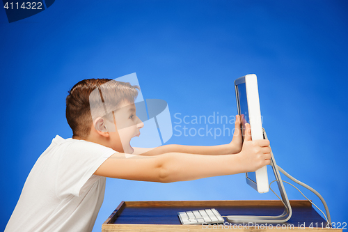 Image of School-age boy sitting in front of the monitor laptop at studio