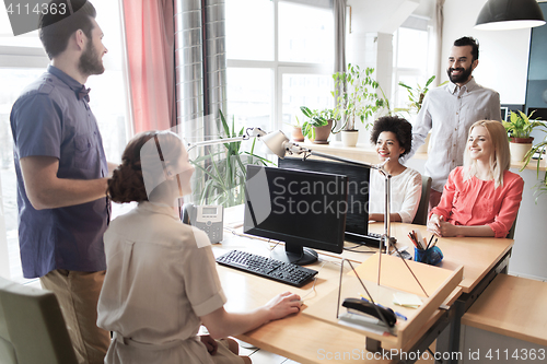 Image of happy creative team talking in office