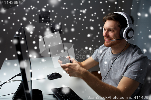 Image of man in headset playing computer video game at home