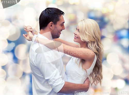 Image of happy couple hugging over lights background