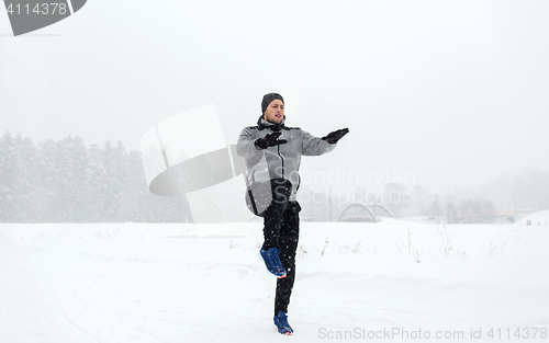 Image of man exercising and warmig up in winter outdoors