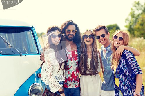 Image of smiling young hippie friends over minivan car