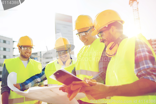 Image of group of builders with tablet pc and blueprint