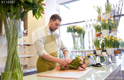 Image of florist wrapping flowers in paper at flower shop