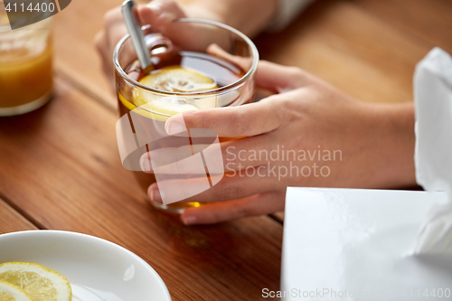 Image of close up of ill woman drinking tea with lemon