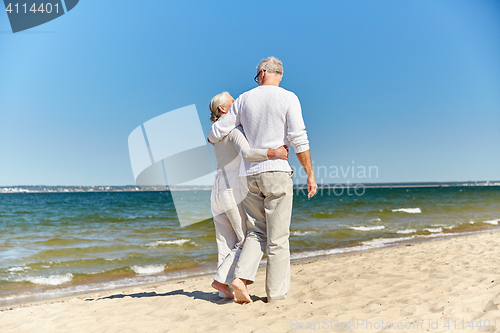 Image of happy senior couple hugging on summer beach
