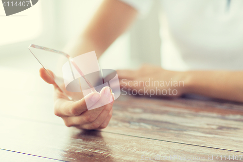 Image of close up of woman with transparent smartphone