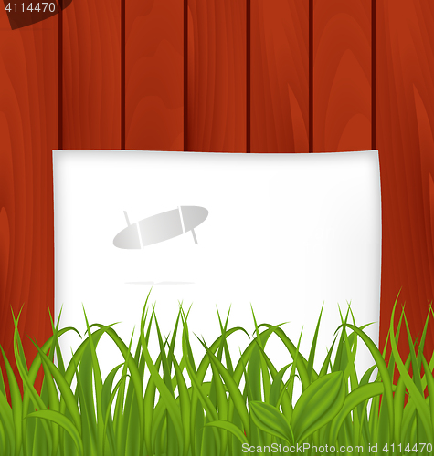 Image of Paper sheet and green grass on wooden texture