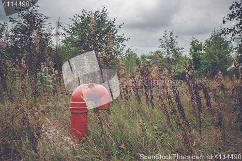 Image of Red pipeline on a rural meadow