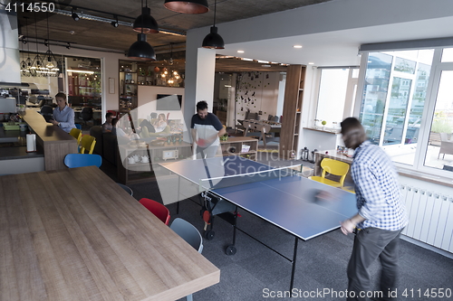 Image of playing ping pong tennis at creative office space