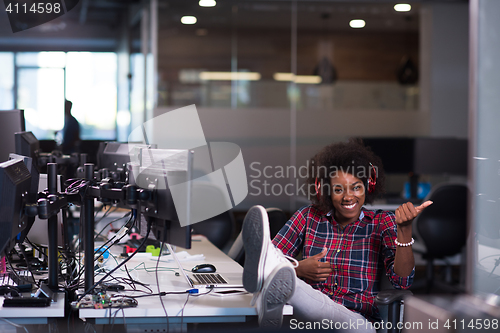 Image of woman at her workplace in startup business office listening musi