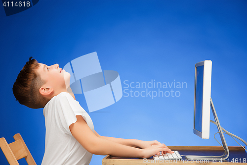 Image of School-age boy sitting in front of the monitor laptop at studio