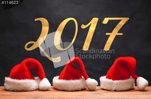 Image of The three Santa red hats on wooden background