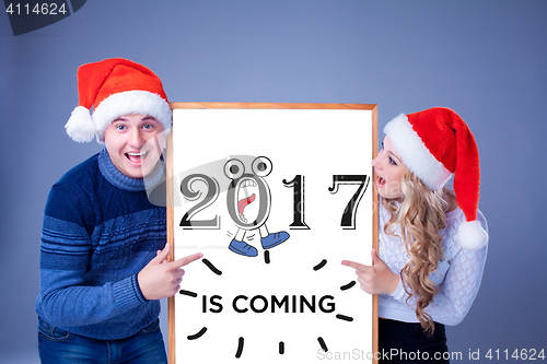 Image of Christmas couple holding white board with empty copy space 