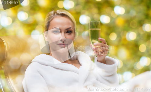 Image of beautiful young woman drinking champagne at spa