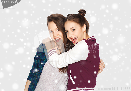 Image of happy smiling teenage girls hugging over snow