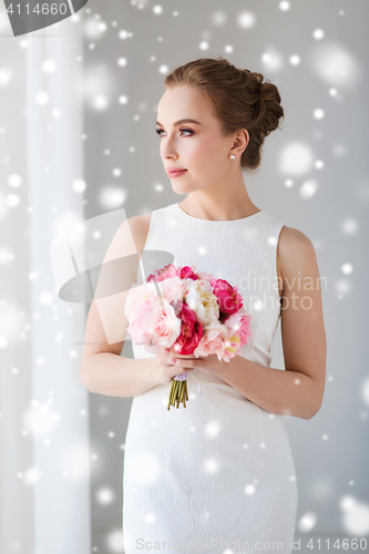 Image of bride or woman in white dress with flower bunch