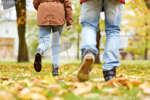 Image of young couple running in autumn park