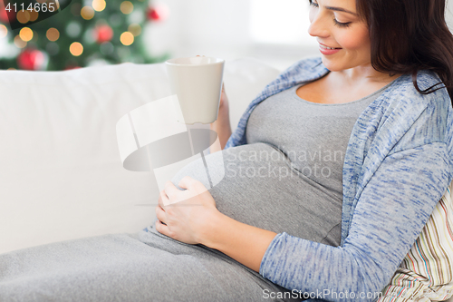 Image of close up of pregnant woman drinking tea at home