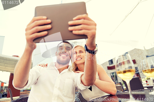 Image of happy couple taking selfie with tablet pc at cafe