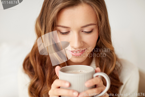 Image of close up of happy woman with coffee cup at home